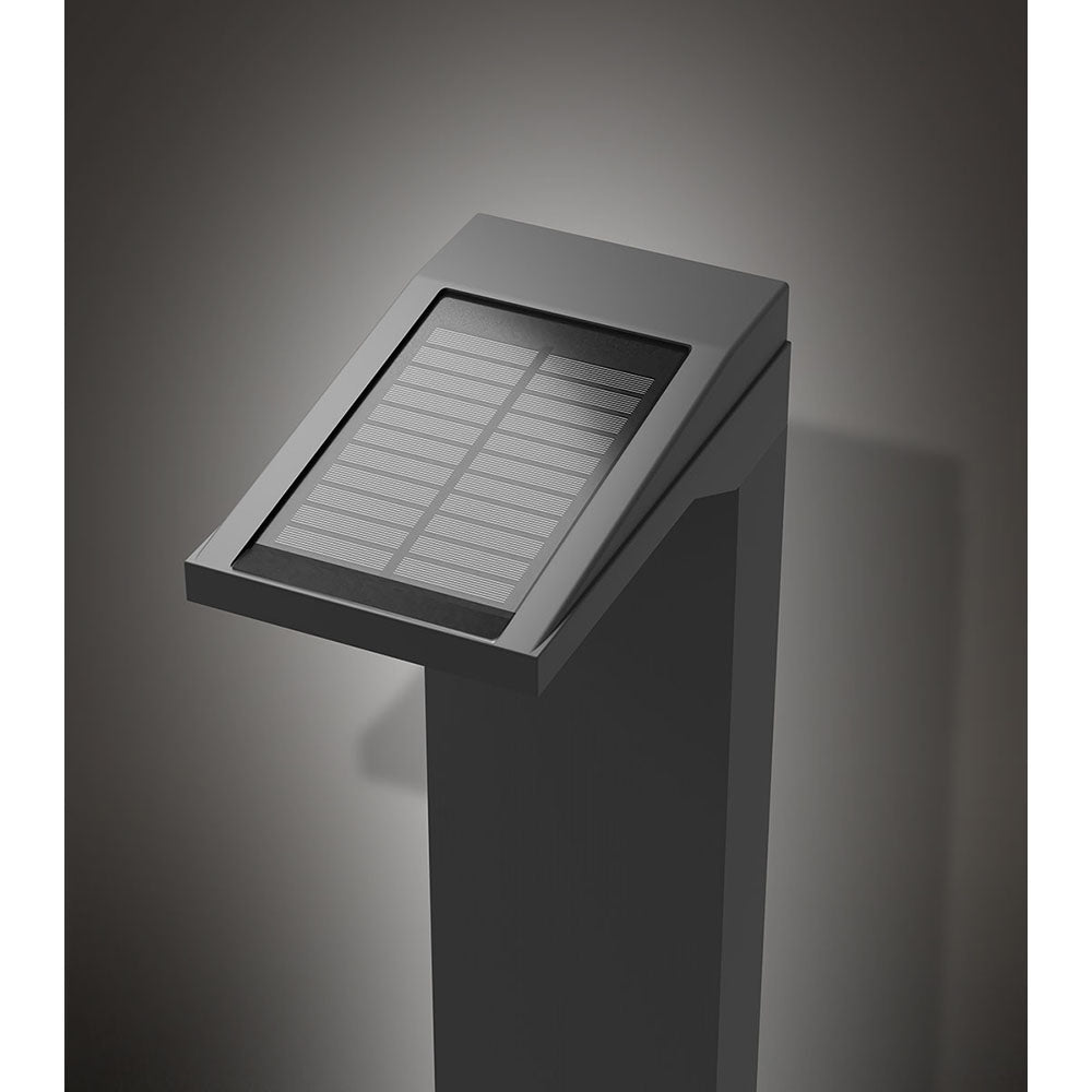 Anthrazitfarbene Solar-Wegeleuchte mit quadratischem Schaft und großem geneigtem Solarpanel oben, seitlicher LED-Lichtaustritt – stimmungsvolle Studioaufnahme auf dunklem Hintergrund.